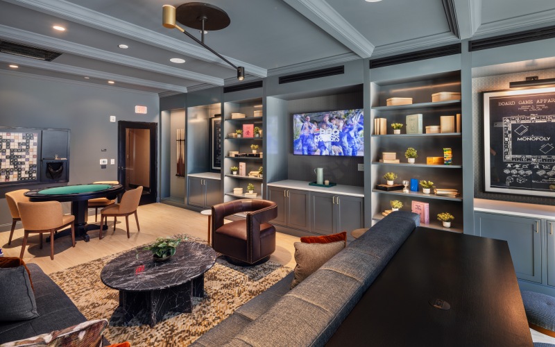 room with game tables with seating and a large tv on the wall